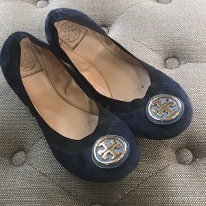 Tory Burch navy suede flats with gold hardware.